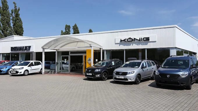 Außenansicht des Autohaus König Renault-Standorts mit mehreren ausgestellten Fahrzeugen vor dem Gebäude.