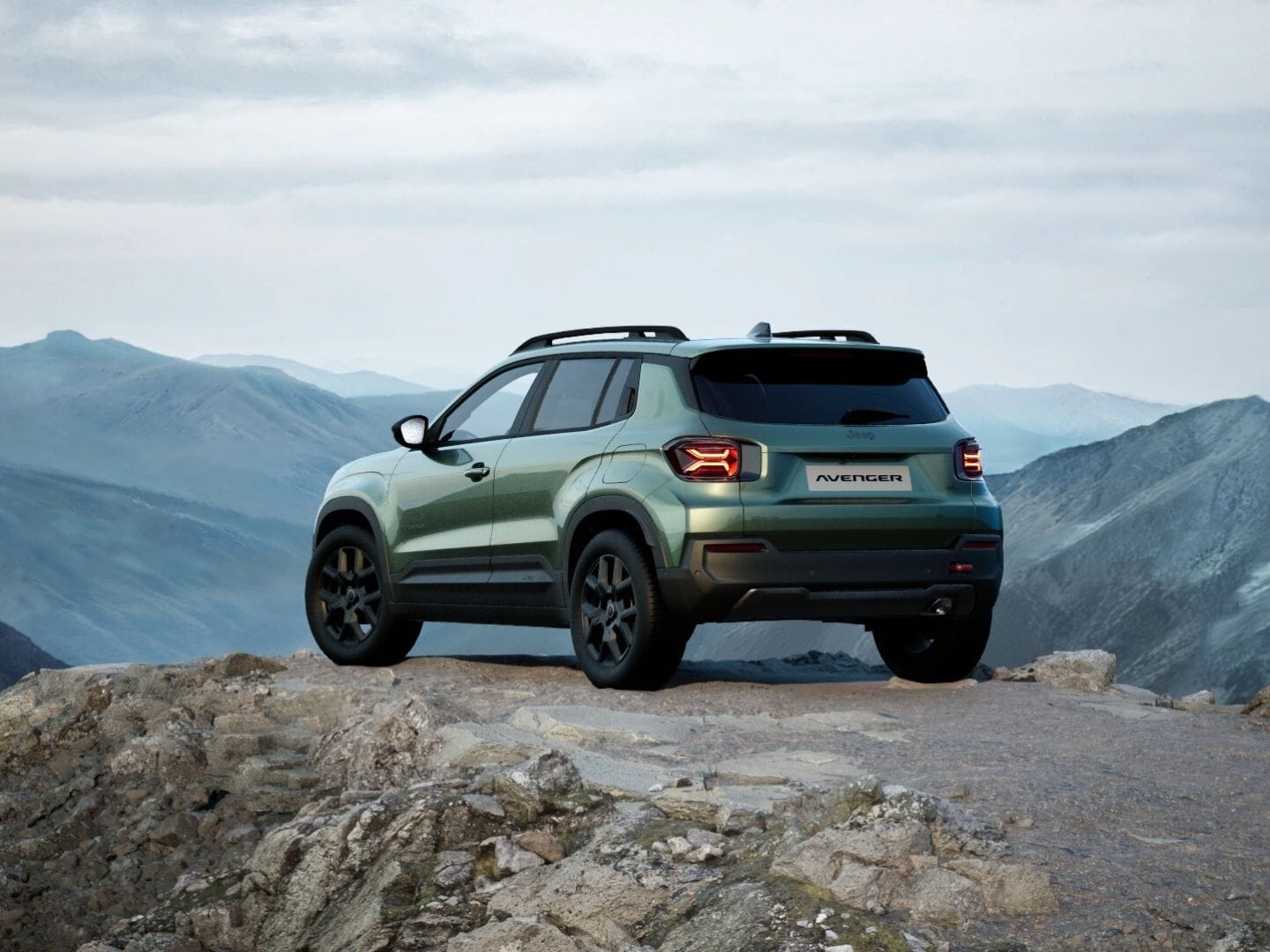 Grüner Jeep Avenger 4xe Upland in Heckansicht vor einer weitläufigen Berglandschaft.