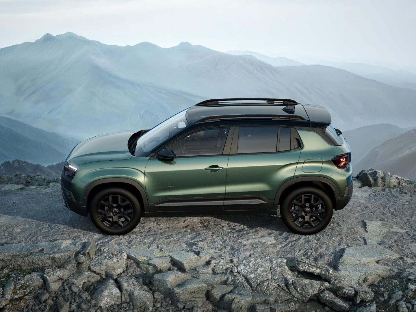 Grüner Jeep Avenger 4xe Upland mit schwarzem Dach in Seitenansicht auf felsigem Gelände.