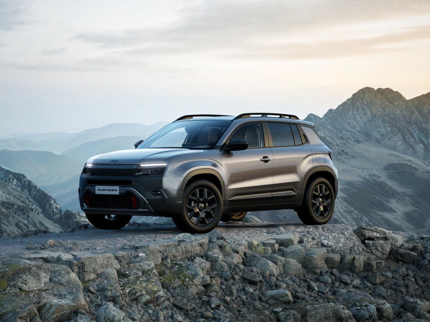Grauer Jeep Avenger 4xe Upland in Frontansicht vor einer Berglandschaft.