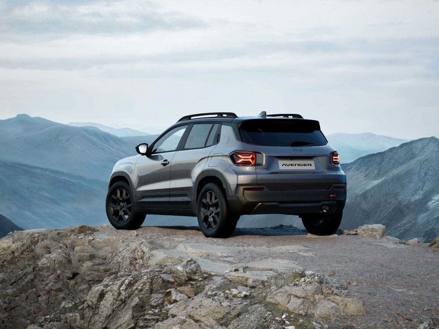 Grauer Jeep Avenger 4xe Upland mit schwarzem Dach in Heckansicht vor einer Berglandschaft.