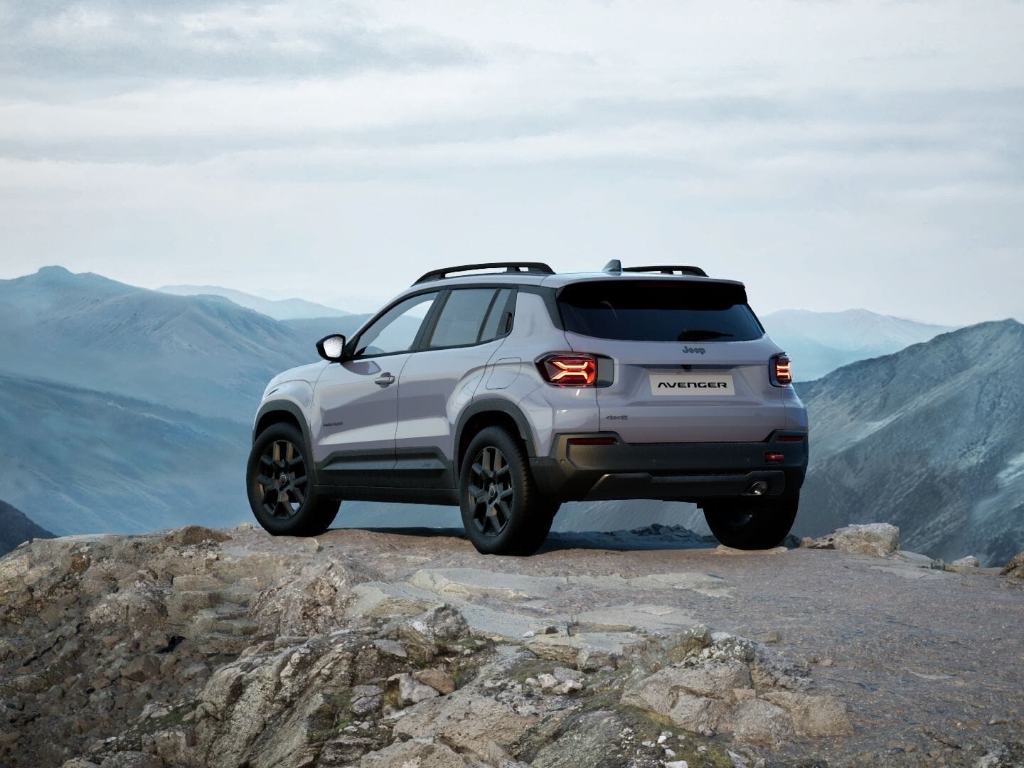 Grauer Jeep Avenger 4xe Upland in Heckansicht vor einer weitläufigen Berglandschaft.