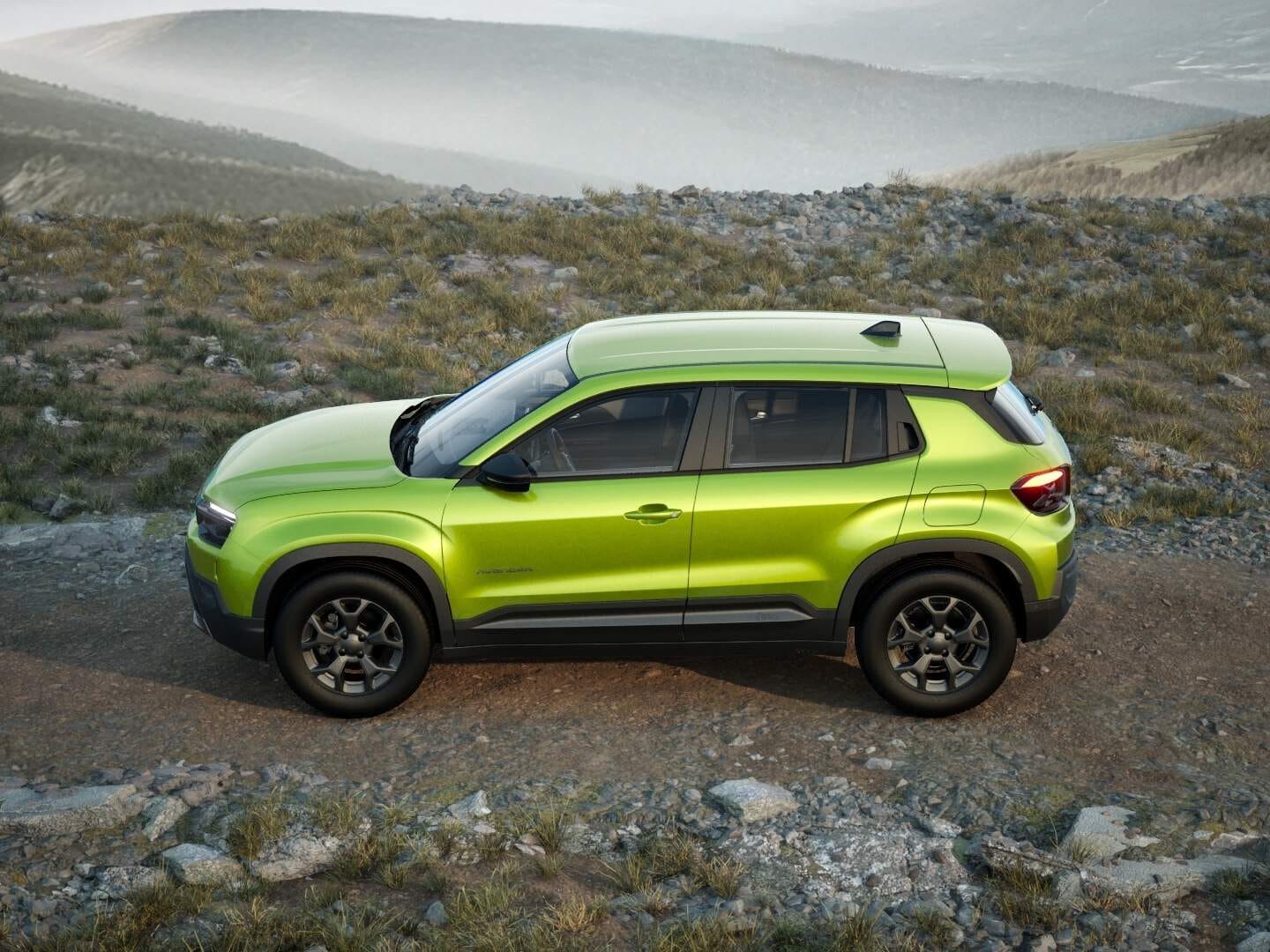 Grüner Jeep Avenger Longitude in Seitenansicht auf einem felsigen Weg in den Bergen.