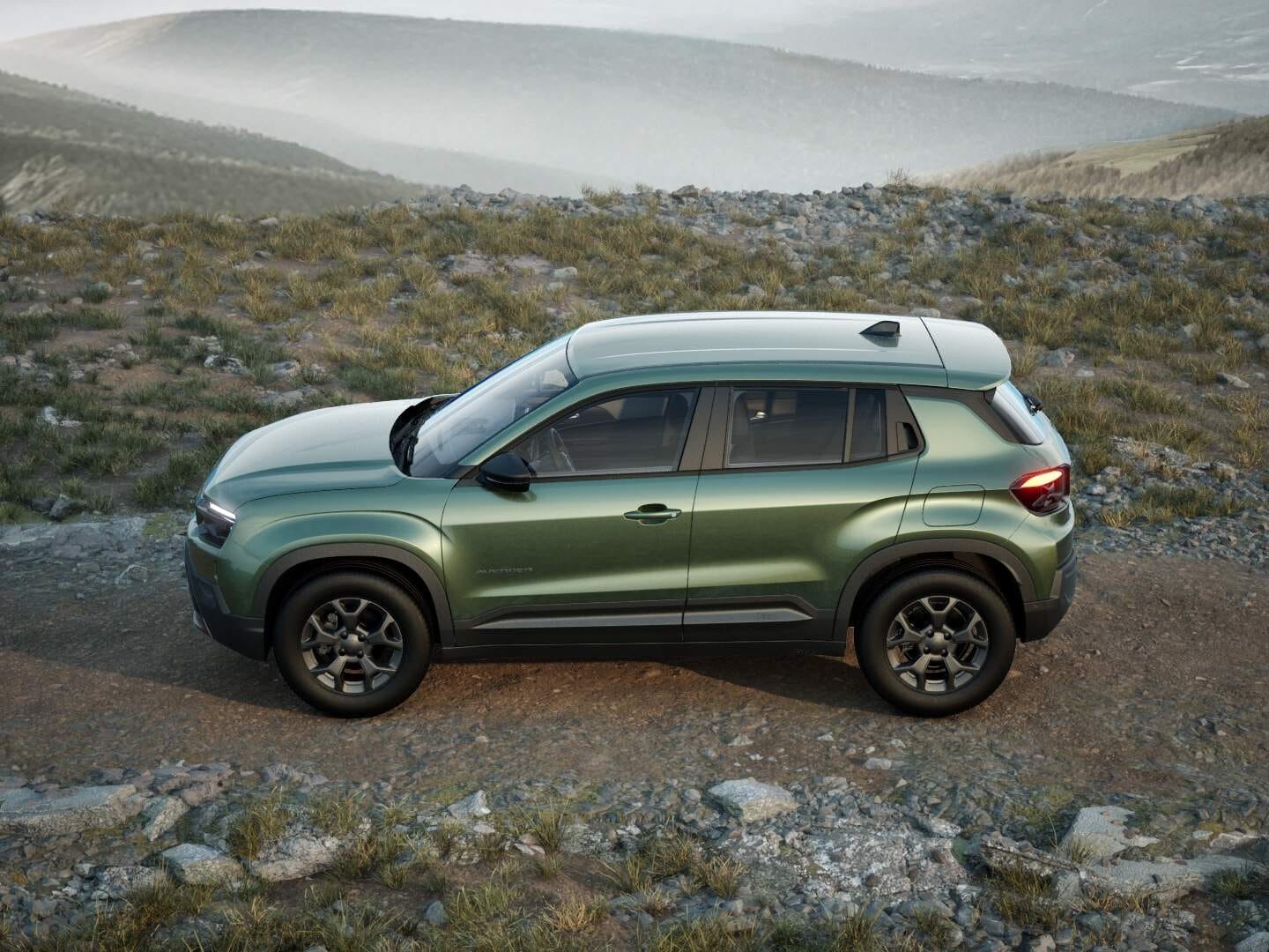 Grüner Jeep Avenger Longitude in Seitenansicht auf einem felsigen Weg in den Bergen.
