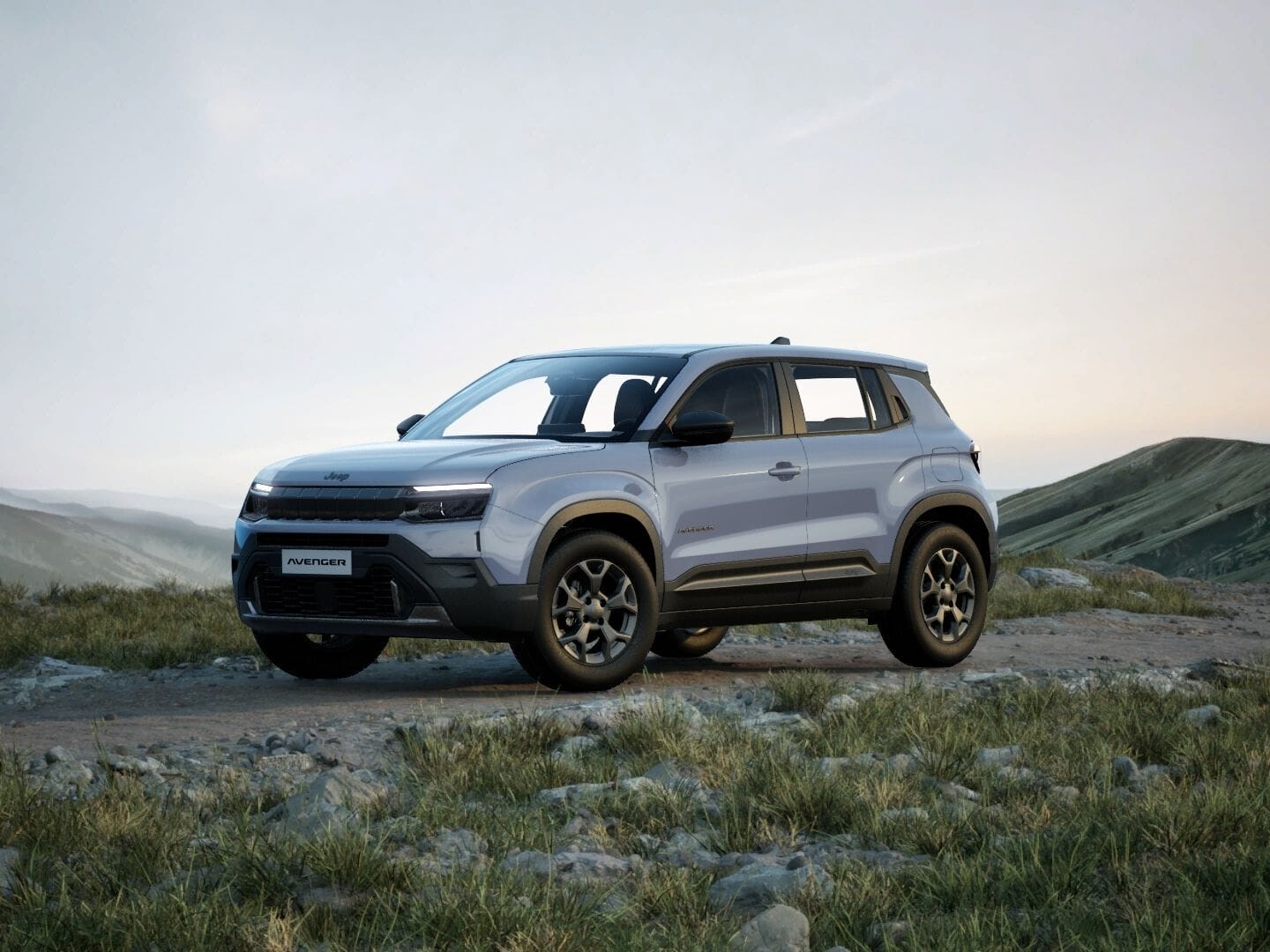 Grauer Jeep Avenger Longitude in Frontansicht vor einer weitläufigen Berglandschaft.