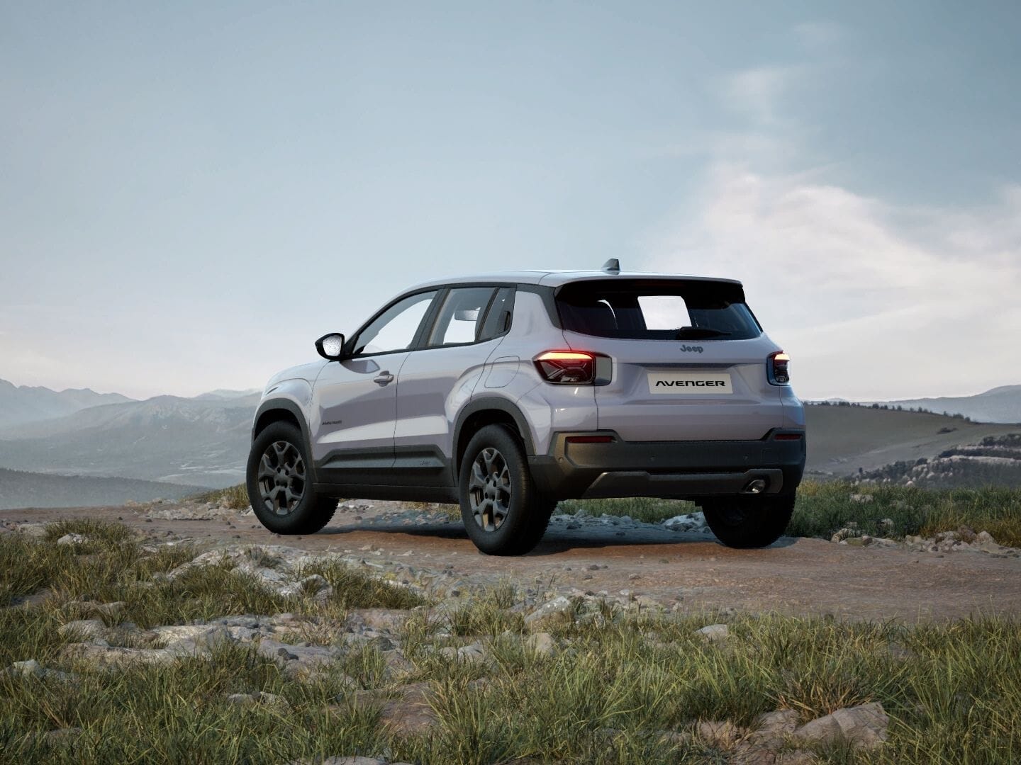 Grauer Jeep Avenger Longitude in Heckansicht vor einer weitläufigen Berglandschaft.