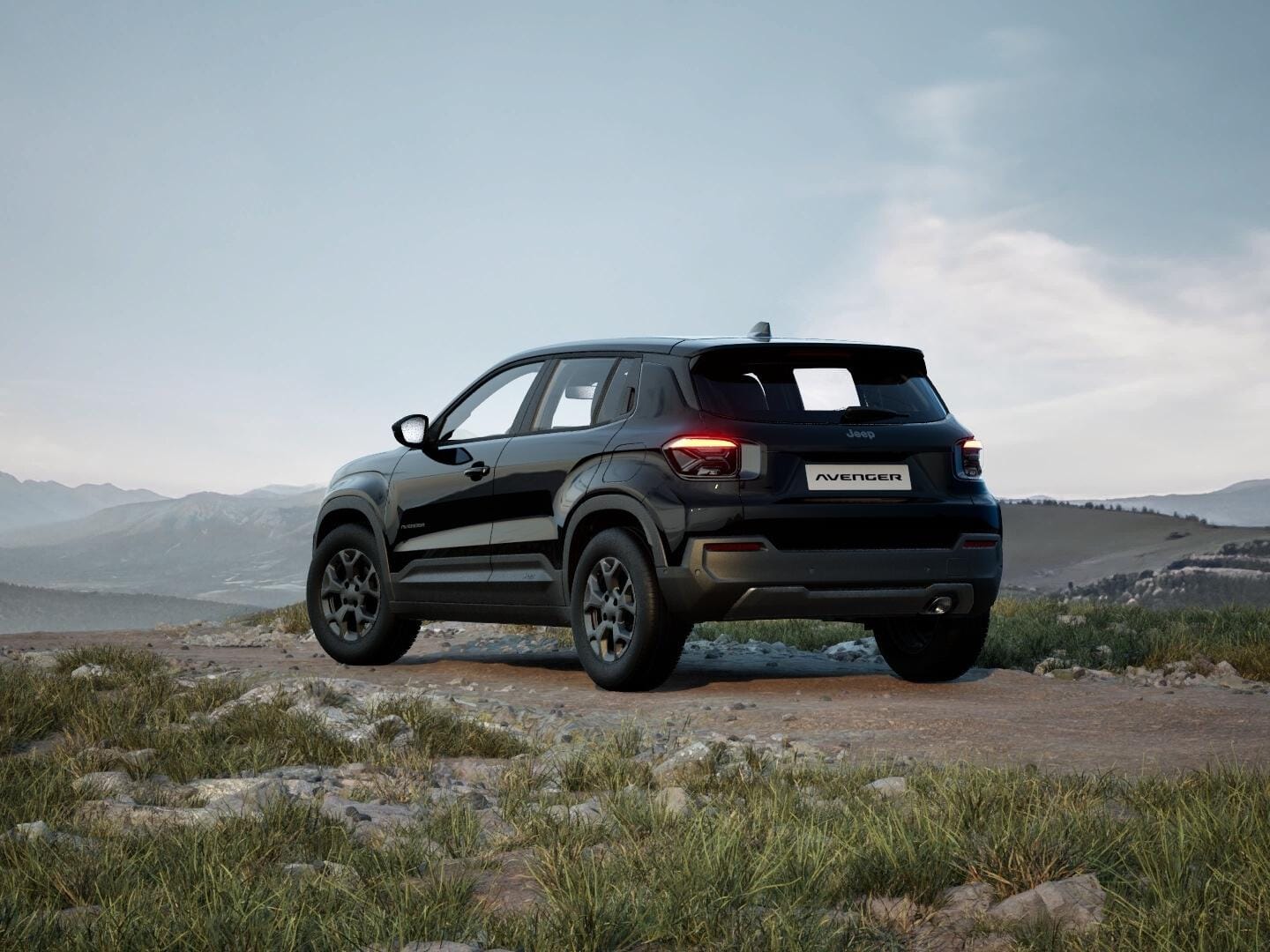 Schwarzer Jeep Avenger Longitude in Heckansicht vor einer weitläufigen Berglandschaft.