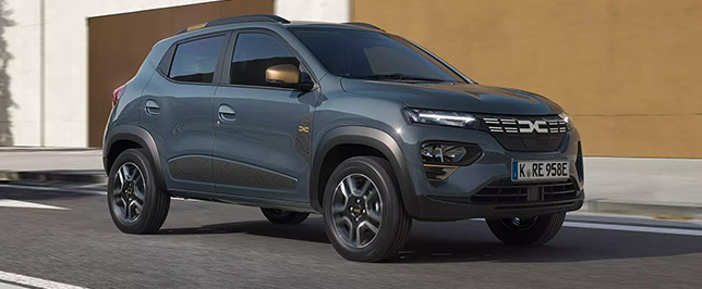 Dunkelgrauer Dacia Spring auf einer Straße.